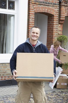 Man with a van service loading furniture into a moving vehicle